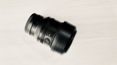Gri ahşap arka planda siyah lens. Lens fotoğrafçılığı.