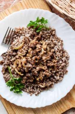 Bahar Morel mantarları ekşi kremaya buğdayla servis edilmiş beyaz tabakta.