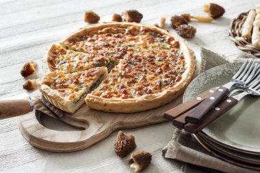 Kiş - ahşap kesim tahtasının üzerinde mantarlı, soğanlı ve mozzarella peynirli turta