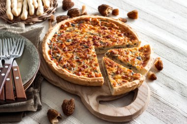 Kiş - ahşap kesim tahtasının üzerinde mantarlı, soğanlı ve mozzarella peynirli turta