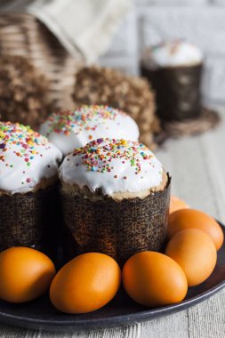 Kapalı paskalya pastaları ve tabakta sarı renkli yumurtalar..