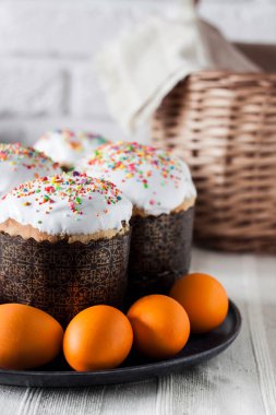 Süslü Paskalya pastaları ve tabakta sarı renkli yumurtalar..