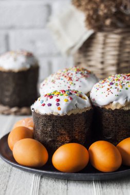 Süslü Paskalya pastaları ve tabakta sarı renkli yumurtalar..