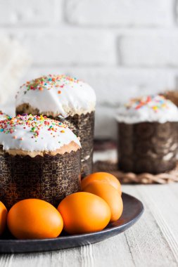 Paskalya pastaları ve sarı renkli yumurtalar masanın üstünde..