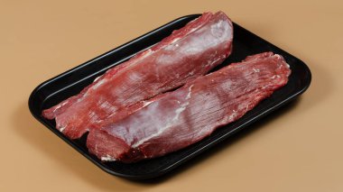 Siyah arka planda çiğ biftek..