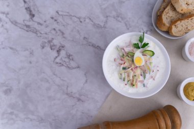 Soğuk çorba, turp, haşlanmış yumurta, limon, ekşi krema, dereotu, maydanoz gibi taze sebzelerin karışımı Okroshka 'nın özünü, ferahlatıcı bir Rus yaz çorbasını güzel bir şekilde somutlaştırır..