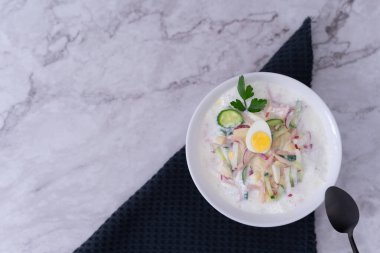 Soğuk çorba, turp, haşlanmış yumurta, limon, ekşi krema, dereotu, maydanoz gibi taze sebzelerin karışımı Okroshka 'nın özünü, ferahlatıcı bir Rus yaz çorbasını güzel bir şekilde somutlaştırır..