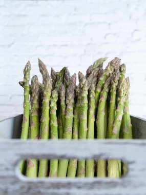 Taze yeşil kuşkonmaz, bu mevsim için mükemmel bir resim olsun diye açık ahşap bir sandığa yerleştirilmiş.