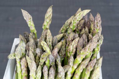 Mevsim için mükemmel bir örnek olarak taze yeşil kuşkonmazları kırsal sandıkta kapatıyoruz.