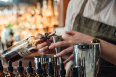 Barmen lüks bir barda içkiyi ölçmek için jigger kullanıyor. Lüks karışımbilim kültürünü ve birinci sınıf içki sanatı detaylarına dikkat çeker..