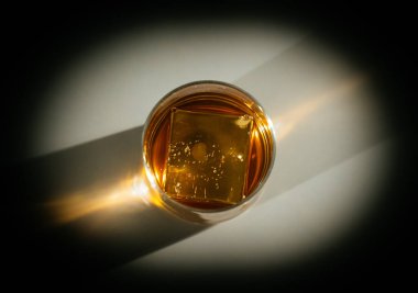 Parlayan buz küpleri ve güneş patlaması yansımalarının yer aldığı klasik bir viski sunumu. Ebedi Amerikan kokteyl prestijini somutlaştırıyor.