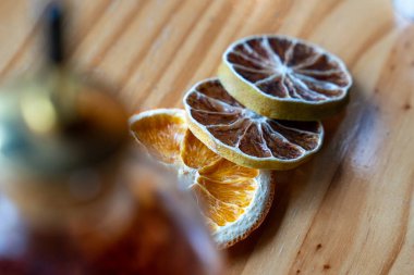 Limon ve portakal da dahil olmak üzere çeşitli kurutulmuş narenciye dilimleri kırsal bir ahşap bar yüzeyinde sergileniyor. Lüks kokteyl sunumları, miksoloji düzenlemeleri ve birinci sınıf garnitür tasarımları için ideal..