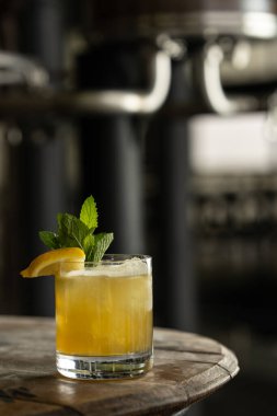 Buzlu viski, buzlu bardakta taze nane şekeri ve limonla süslenmiş, kırsal bir fıçıda oturuyor..