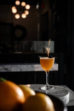 Karamsar ışıklandırmalı sofistike bir bar ortamında servis edilen zarif bir kokteyl..