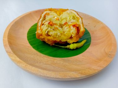 Kızarmış Tofu ya da içinde sebzeler olan Tahu Isi, ikiye bölünmüş. Endonezya 'dan popüler geleneksel atıştırmalıklar. Tahta bir tabakta, yuvarlak bir muz yaprağında servis edilmiş, beyaz bir arka planda izole edilmiş..