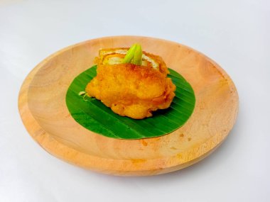 Kızarmış Tofu ya da içinde sebzeler olan Tahu Isi, ikiye bölünmüş. Endonezya 'dan popüler geleneksel atıştırmalıklar. Tahta bir tabakta, yuvarlak bir muz yaprağında servis edilmiş, beyaz bir arka planda izole edilmiş..