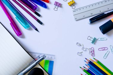 Beyaz Arkaplanda Renkli Kırtasiye Eşyaları Ayarlandı. Beyaz arka planda kalem, kalem, cetvel, ataç ve ataç gibi renkli kırtasiye malzemelerinin düzenli bir şekilde düzenlenmesi, ofis veya okulun temel ihtiyaçlarını göstermek için ideal.
