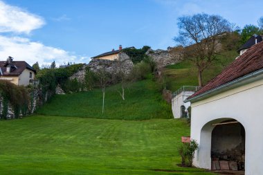 Green Hillside 'daki Tarihi Taş Duvar ve Evlerin Manzarası. Tarihi taş duvarları, evleri ve yemyeşil çimenleri olan pitoresk bir yamaç..
