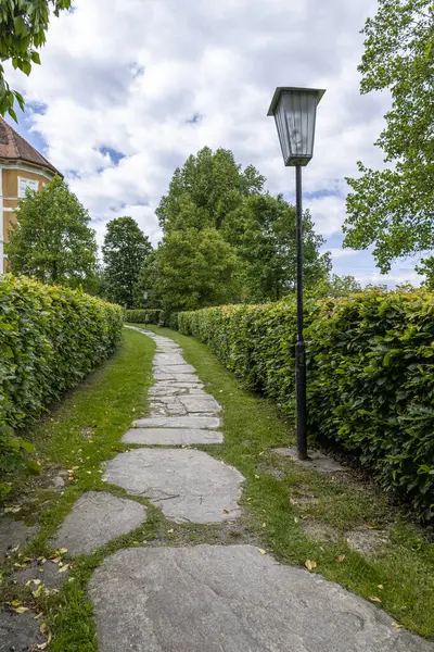 Lush Garden 'daki Manzaralı Taş Yol. Çitlerle ve ağaçlarla kaplı, manzaralı bir bahçeye uzanan taş bir patika.
