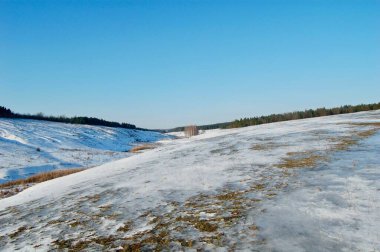 Uçsuz bucaksız, karlı bir manzara solgun bir gökyüzünün altında uzanır. Çıplak ağaçlar soğuğa karşı durur, ve dünya yumuşak beyaz karla kaplıdır, sakin, kış harikalar diyarı yaratır..