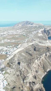 Dikey video, Oia kasabası, Santorini üzerinde 360 derecelik uçuş. Ada ve deniz manzarası. Yüksek kalite 4k görüntü
