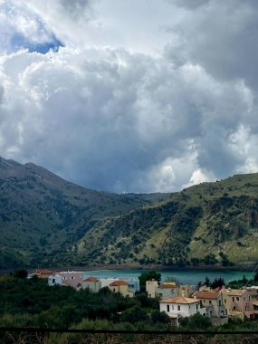 Kournas Gölü manzarası, çevresindeki dağlar ve Girit 'teki evler. Yüksek kalite fotoğraf