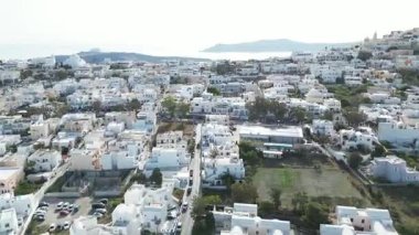 Yunanistan 'ın ünlü Santorini adasındaki Fira' nın geleneksel beyaz boyalı evleri üzerinde insansız uçak uçuşu. Yüksek kalite 4k görüntü