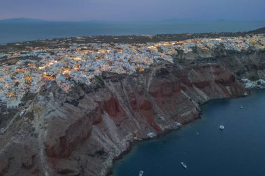 Aydınlanmış Santorini ve karanlık çöktüğünde Oia kasabasının havadan görünüşü. Yüksek kalite fotoğraf