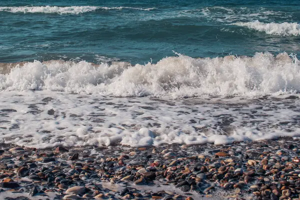Dalgalar dramatik sıçramalarla sahile çarpıyor. Yüksek kalite fotoğraf