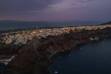 Aydınlanmış Santorini ve karanlık çöktüğünde Oia kasabasının havadan görünüşü. Yüksek kalite fotoğraf