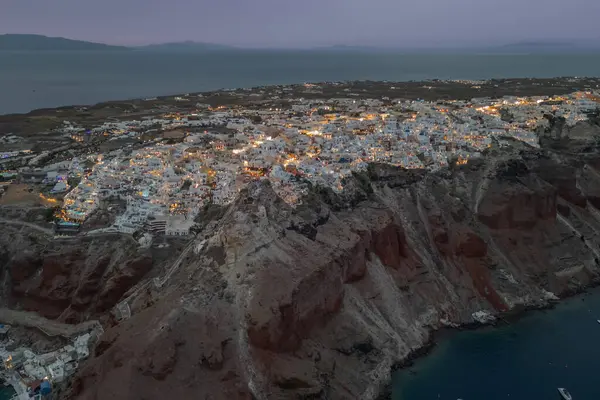 Aydınlanmış Santorini ve karanlık çöktüğünde Oia kasabasının havadan görünüşü. Yüksek kalite fotoğraf