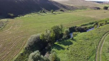 Mariupol, Donetsk bölgesi yakınlarındaki tarlalar arasındaki küçük bir nehir boyunca insansız hava aracı görüntüleri. Yüksek kaliteli FullHD görüntüler