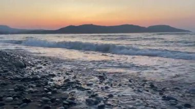 Gün batımında güzel deniz ve çakıl taşı plajı Girit. Yüksek kalite 4k görüntü