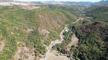 Georgia 'daki İHA görüntüleri orman tepeleri arasında yol üzerinde uçuyor. Yüksek kalite 4k görüntü