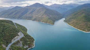 Gürcistan 'daki Zhinvali Barajı. Yeşil dağ ve ormanlarla çevrili manzaralı göl. İnsan yapımı güzelliğin bir örneği. Yüksek kalite fotoğraf