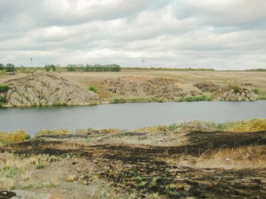 Gölün yakınındaki koruma altındaki doğal bir bölgede çıkan yangından sonra yanmış otlar. Ateşe dikkat et. Yüksek kalite fotoğraf
