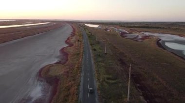 İnsansız hava aracı atışı: Ukrayna 'nın Mariupol bölgesindeki Belosarayska Spit' te Bilosaraysky Ornitoloji Bölgesi 'nde bataklıklar ve kırmızı algler arasında yavaşça giden bir araba. 16 Eylül 2021. Yüksek kaliteli FullHD görüntüler