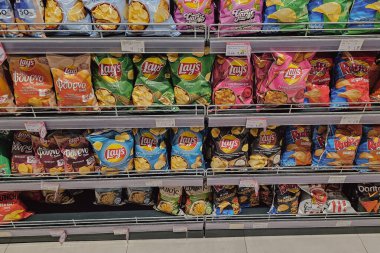 Georgioupoli, Yunanistan. 20 Mart 2025. Çeşitli çipler, farklı tatlar ve ambalajlarla vitrin görüntülerini depola. Yüksek kalite fotoğraf