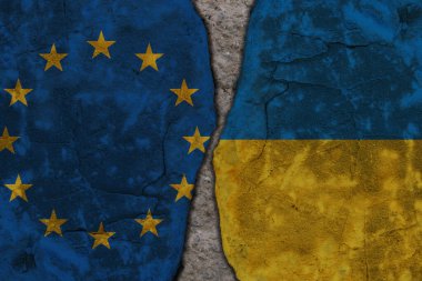 Kırık taş duvar dokusunda Avrupa Birliği ve Ukrayna bayrakları arasındaki sembolik bölünme. Yüksek kalite fotoğraf