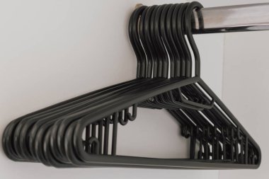 Boş gardıroptaki yetişkinler için plastik siyah askılar. Yüksek kalite fotoğraf