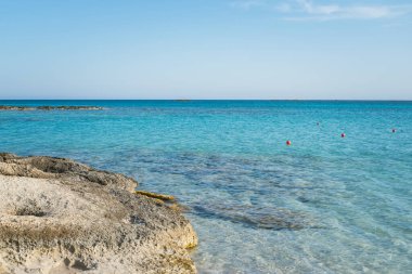 Şeffaf turkuaz deniz suyu ve kayalık plaj, temiz deniz yatağı ve suda kurtarma şamandıraları. Yüksek kalite fotoğraf