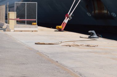 Rıhtımdaki iskeleye demirleme halatlarını kullanarak bir gemiyi demirlemek. İyi kalite fotoğraf.