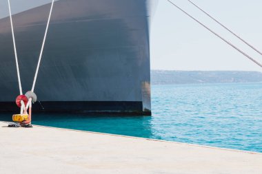 Rıhtımdaki iskeleye demirleme halatlarını kullanarak bir gemiyi demirlemek. İyi kalite fotoğraf.