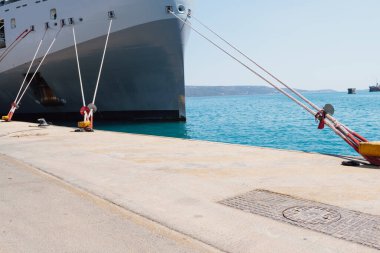 Rıhtımdaki iskeleye demirleme halatlarını kullanarak bir gemiyi demirlemek. İyi kalite fotoğraf.