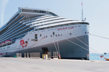 Hanya, Yunanistan. 19 Ağustos 2025. Büyük yolcu gemisi Resilient Lady Virgin Yunanistan 'ın Girit limanı Souda' ya yanaştı. Lüks bir turizm gemisi ve güneşli gökyüzü altında seyahat ediyor.
