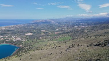 Güzel Girit manzarası Kournas Gölü deniz dağları ve zeytin tarlaları, Yunan Akdeniz manzarası ılık güneş ışığı.
