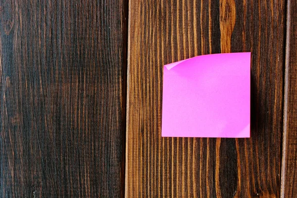 purple sticker on a wooden wall for a notes