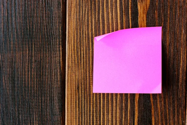 purple sticker on a wooden wall for a notes