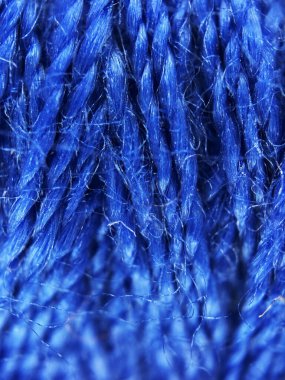 Mavi iplik dokusuna yakın çekim, pürüzsüz vurgulama, hatta iplikler ve ince detaylar. Rengi ve ince dokuması onu el işi, dikiş ve tekstil temalı stok fotoğrafları için ideal kılıyor..