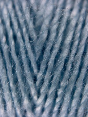 Pürüzsüz dokuyu ve zengin rengi vurgulayan mavi dikiş ipliğinin ayrıntılı yakın çekimi. Dikiş, el işi, tekstil veya sanat tasarımı ile ilgili stok resimleri için idealdir.